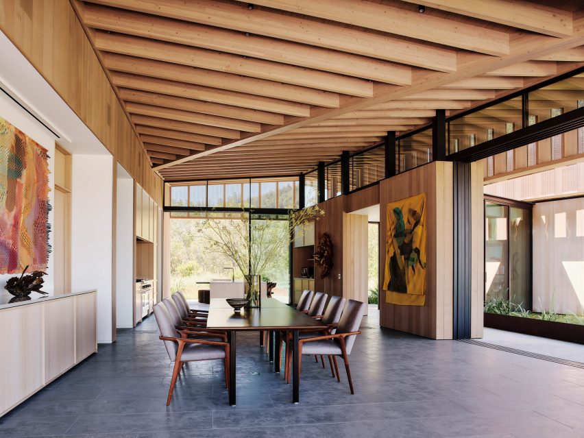 A dining room with large art and post and beam ceiling