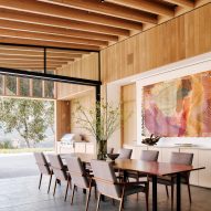 A dining room with large art and post and beam ceiling