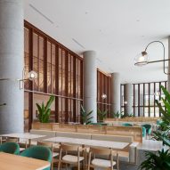 Hotel dining space with wood furniture and planting