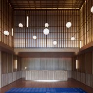 Wood-clad hotel interior with spherical lantern lights
