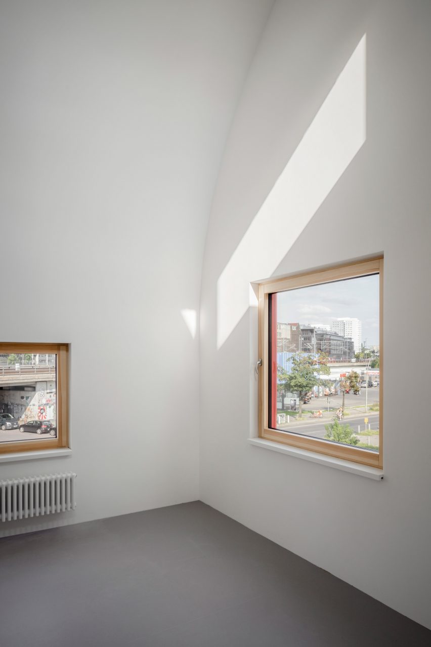 White room with timber-framed windows and a curved ceiling