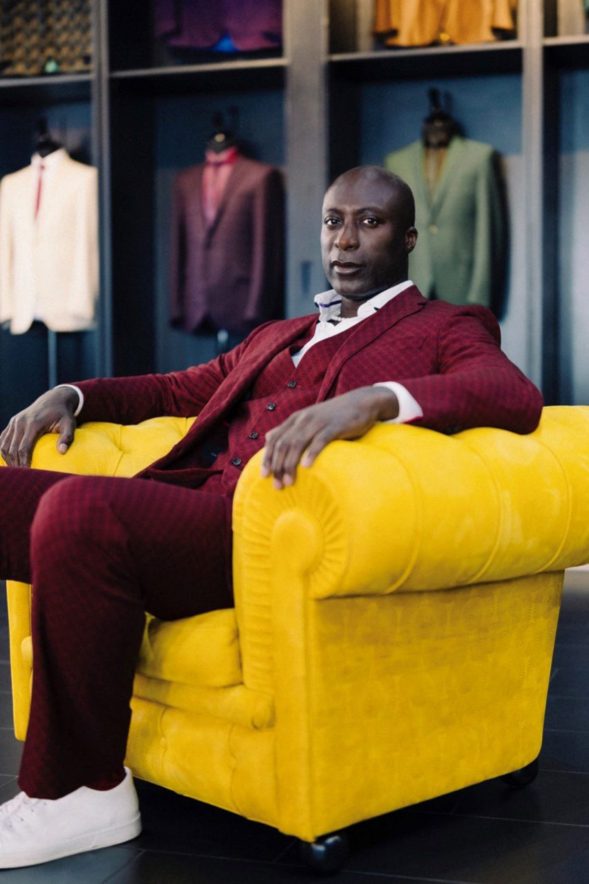 Ozwald Boateng sitting in yellow Chester armchair with embossed leather finish by Poltrona Frau