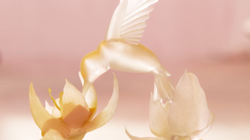 Photo of a hummingbird figurine on a pale pink background