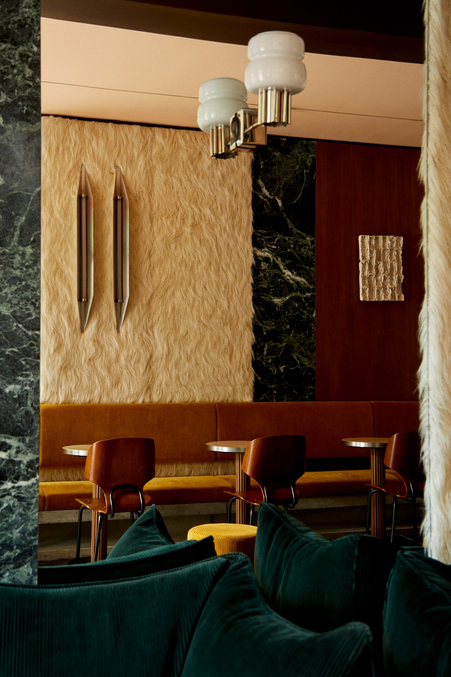 A cafe interior with faux fur, green marble and walnut walls