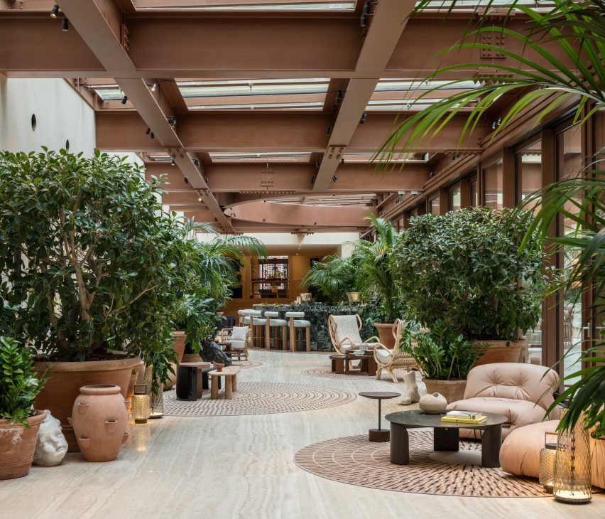 Open lobby with pockets of seating between potted plants in Six Senses Rome hotel by Patricia Urquiola
