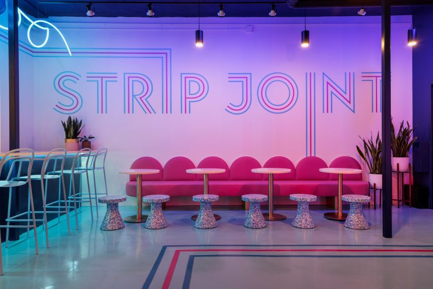 The words "Strip Joint" written on a wall in a striped typeface