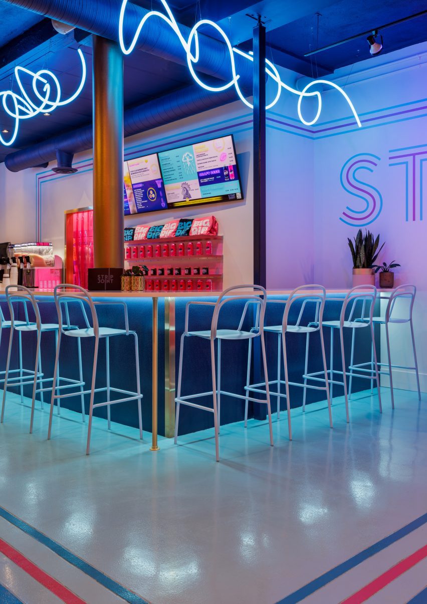 Fluorescent-blue neon tubes suspended above a service counter