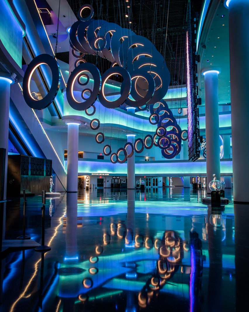 Atrium with shiny black floors and walls lit up in blue