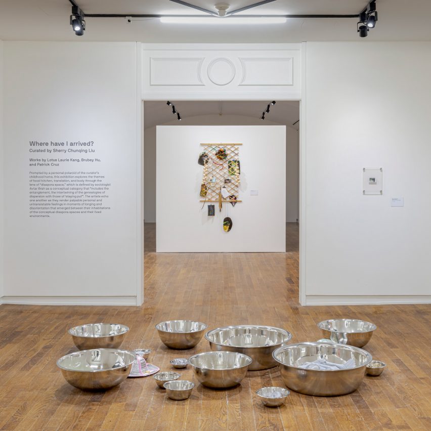 Photo of an exhibition with metal bowls on floor in gallery room