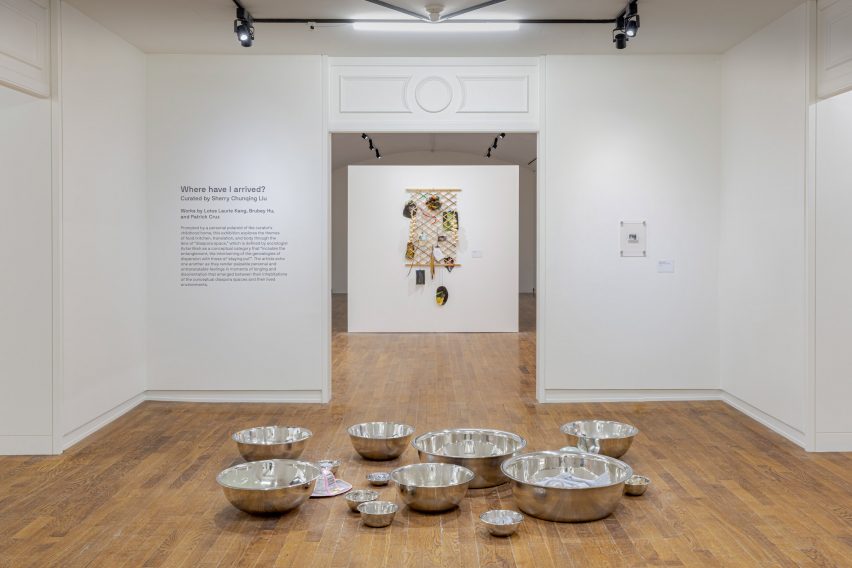 Photo of an exhibition with metal bowls on floor in gallery room