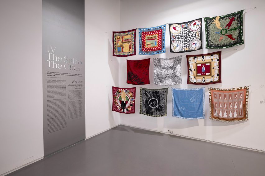 Photo showing a corner of an exhibition with 11 scarves hung up