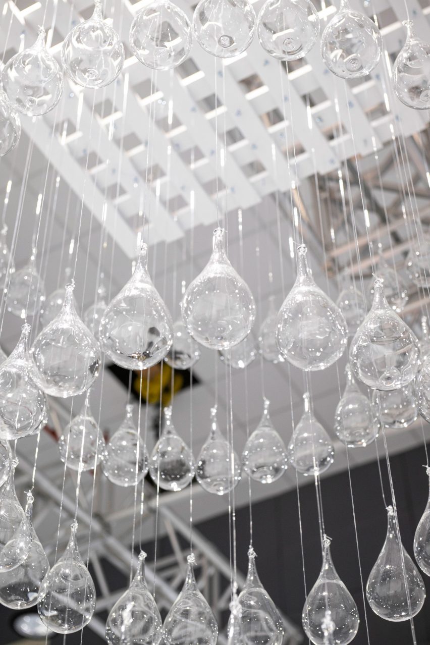 Photograph of a ceiling-mounted sculpture with glass raindrops suspended beneath it