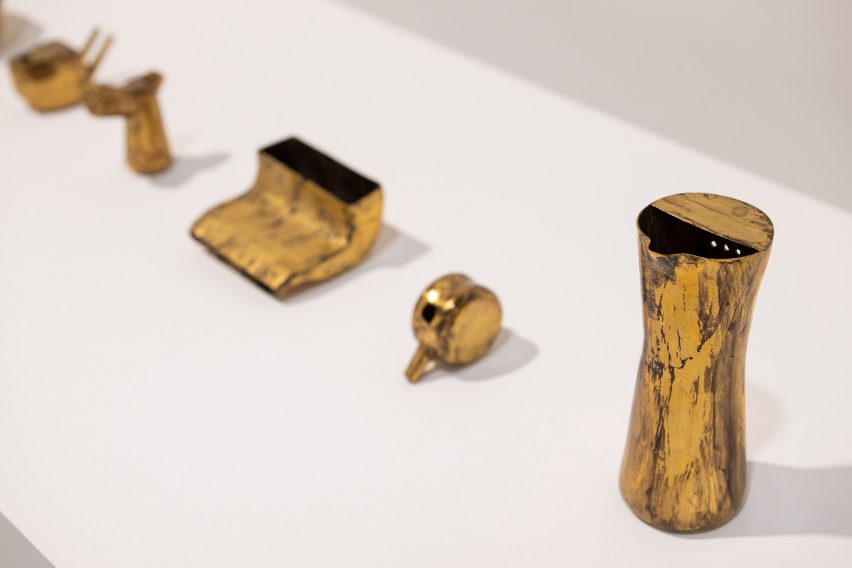 Photo of gold-coloured vessels on a white plinth