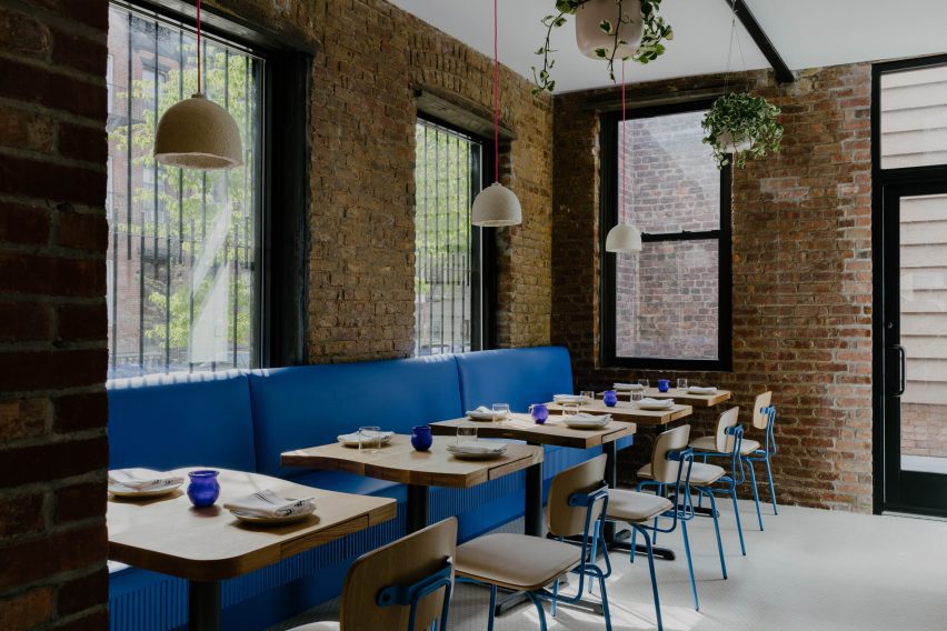 Dining room with cobalt-coloured seating and exposed brick walls