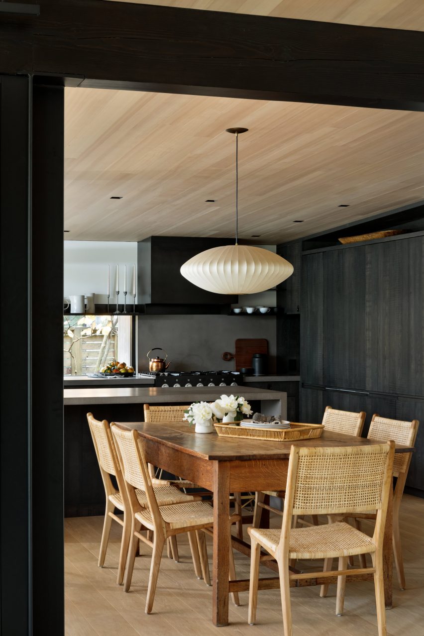 Wood dining table and chairs in front of grey kitchen