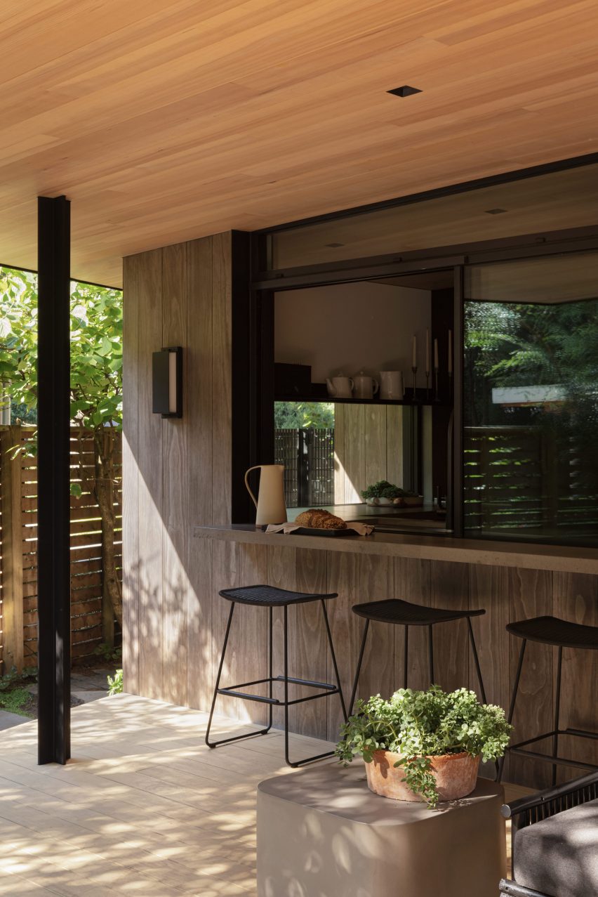 Kitchen connected to a patio via a bar counter and sliding window