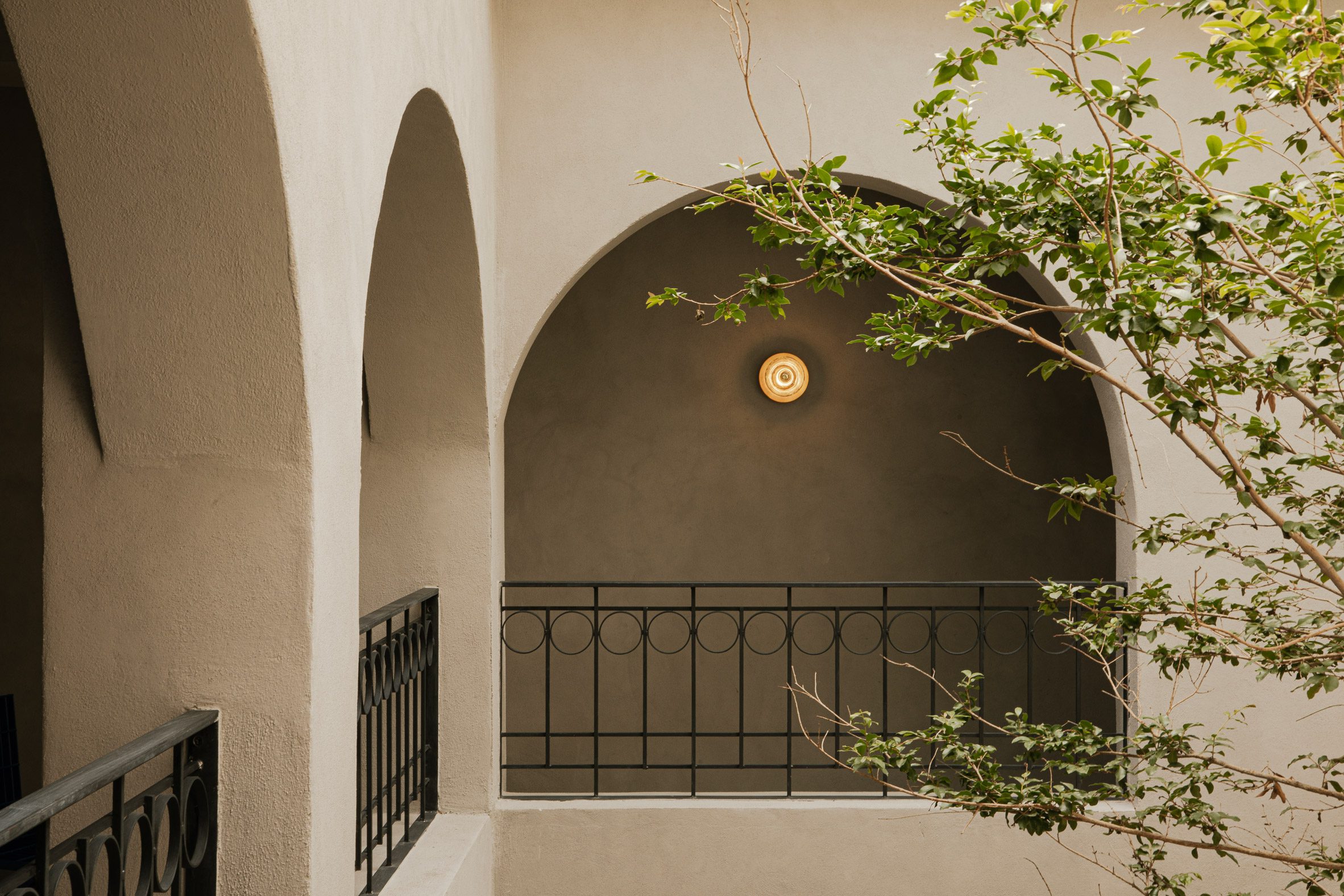 Arched openings with black cast-iron handrails