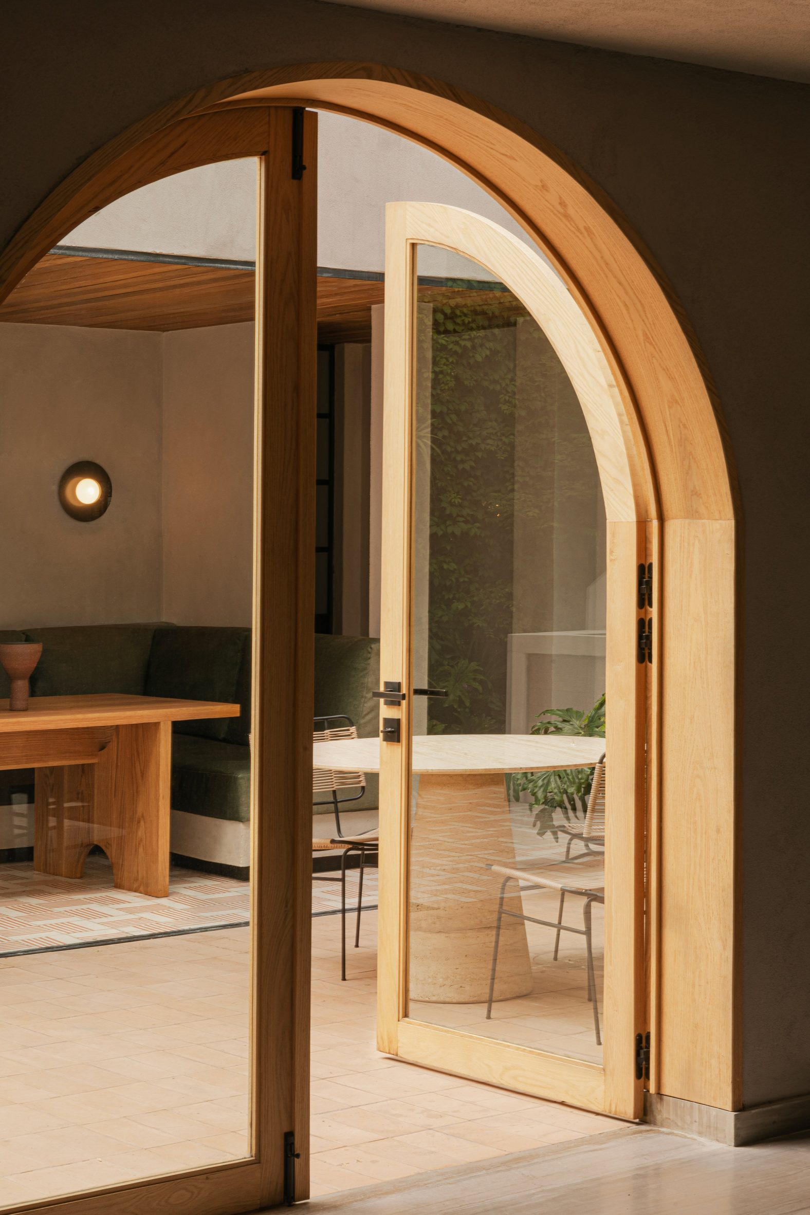 Arched wood-framed glass door leading out to a courtyard