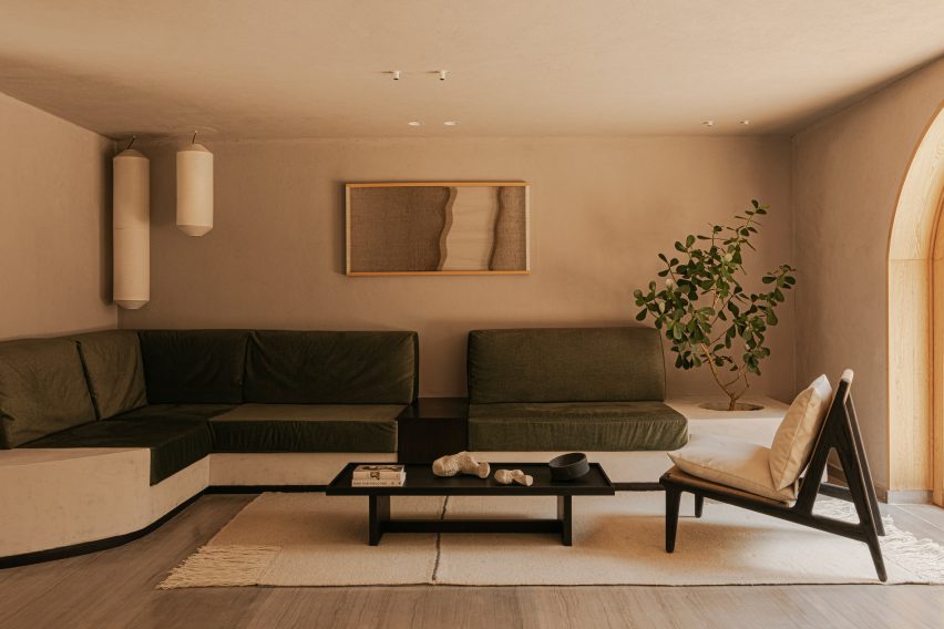 Living room with neutral decor and moss green sofa upholstery