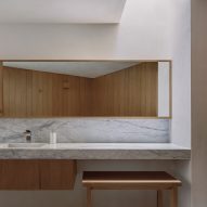 Bathroom with marble surfaces and wood furniture