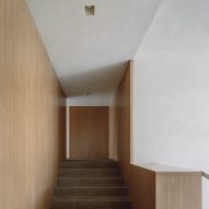 Staircase landing with wood-lined walls