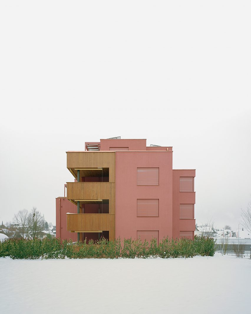 Apartment complex coated in red plaster by Ductus