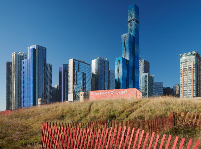 Orange pavilion with text reading Who Found Chicago? With Chicago skyline in the background