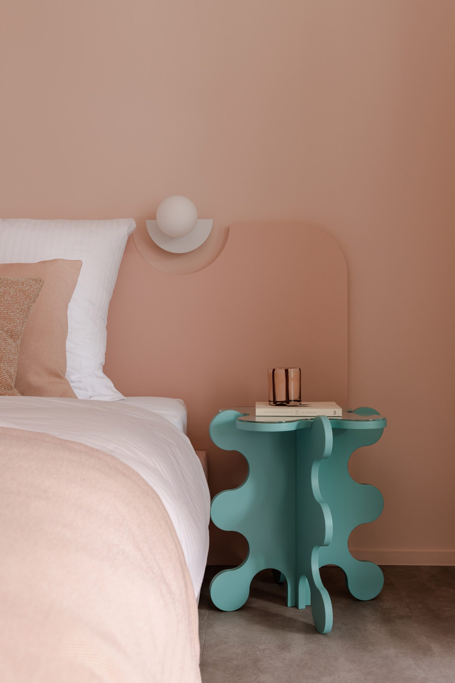 Curvy bedside table within the pink bedroom