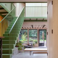 Green-painted stairs in an open-plan living area