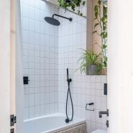 Bathroom with a white bathtub and white wall tiles