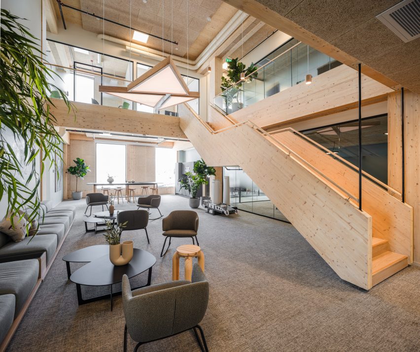 Double height atrium in the green timber clad office in Norway by Oslotre