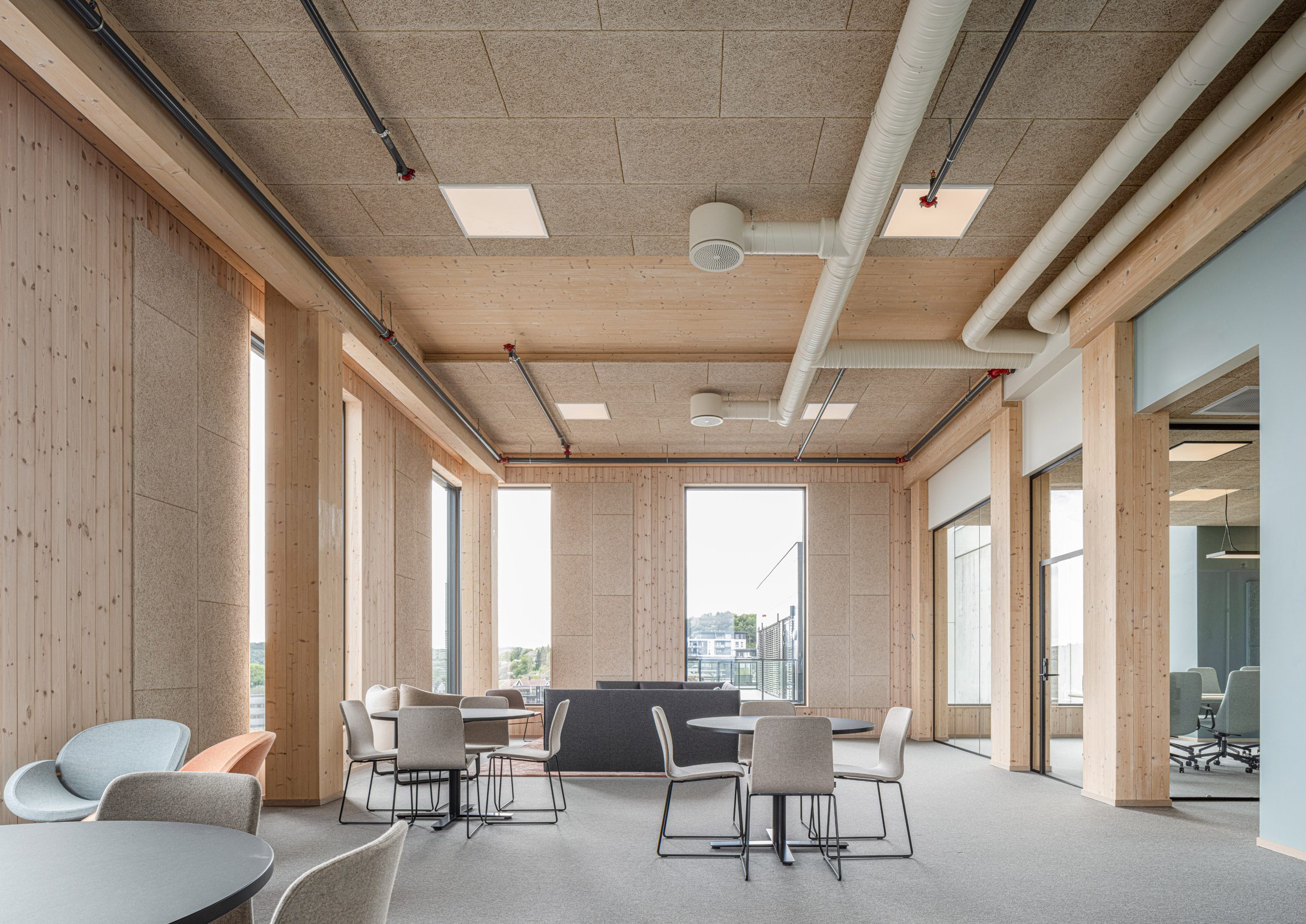Exposed interiors of the green timber clad office in Norway by Oslotre