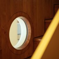 from the stairs a porthole provides light and visual access to room below