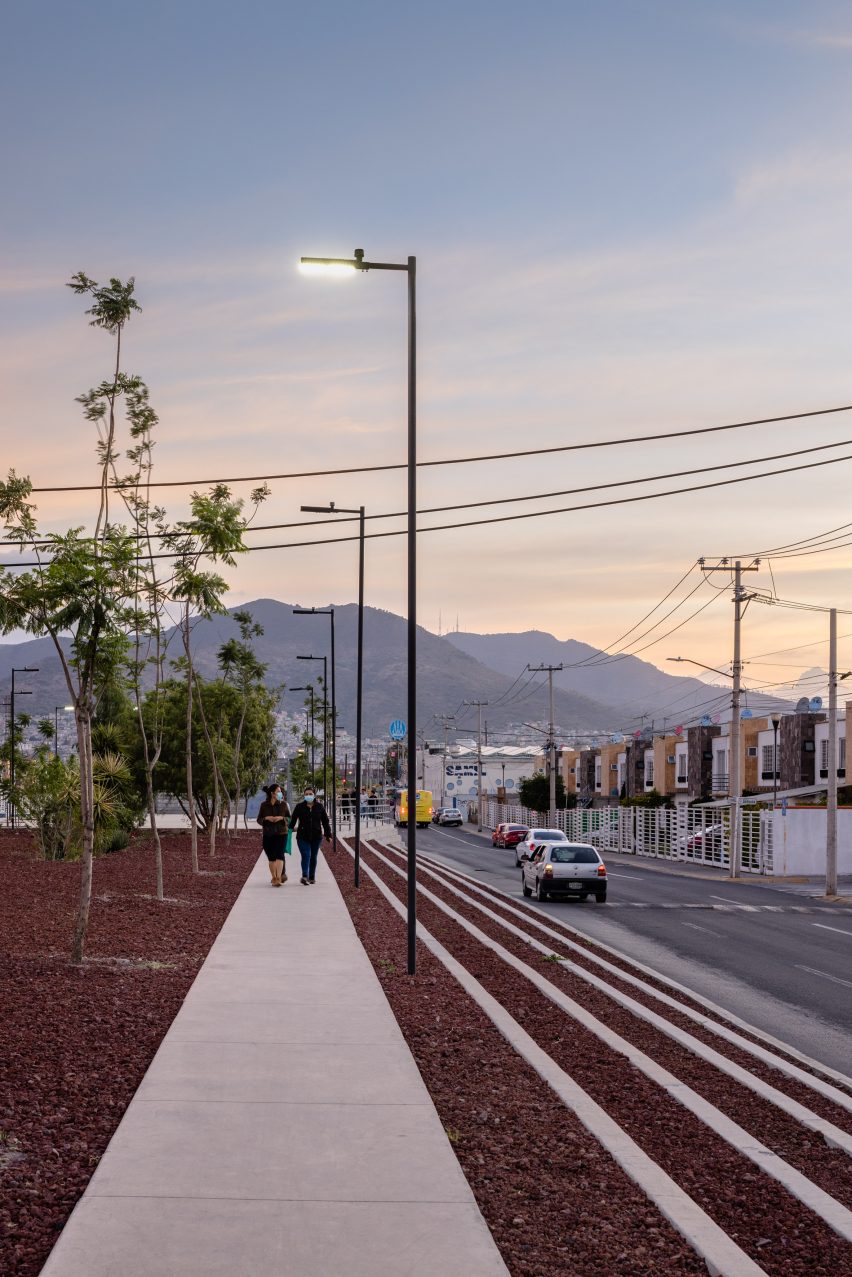 Two people walking down linear park with mountains in the background