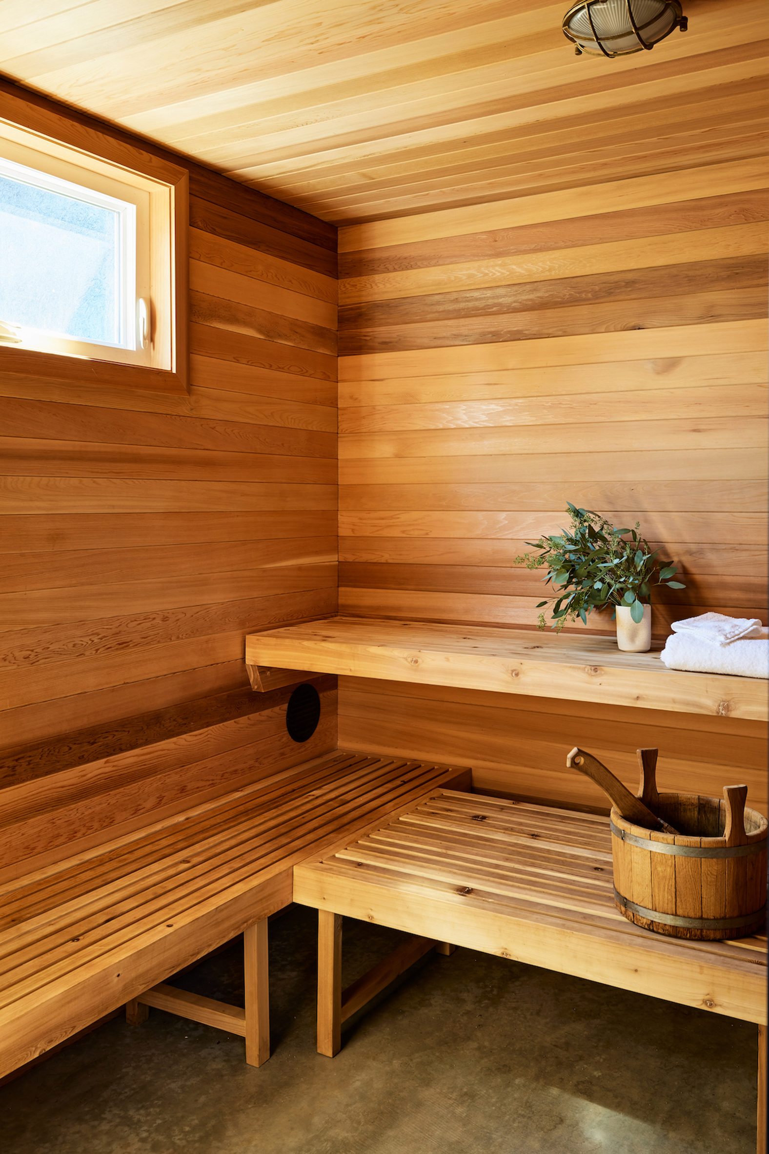 Wood-lined sauna with benches and a water bucket