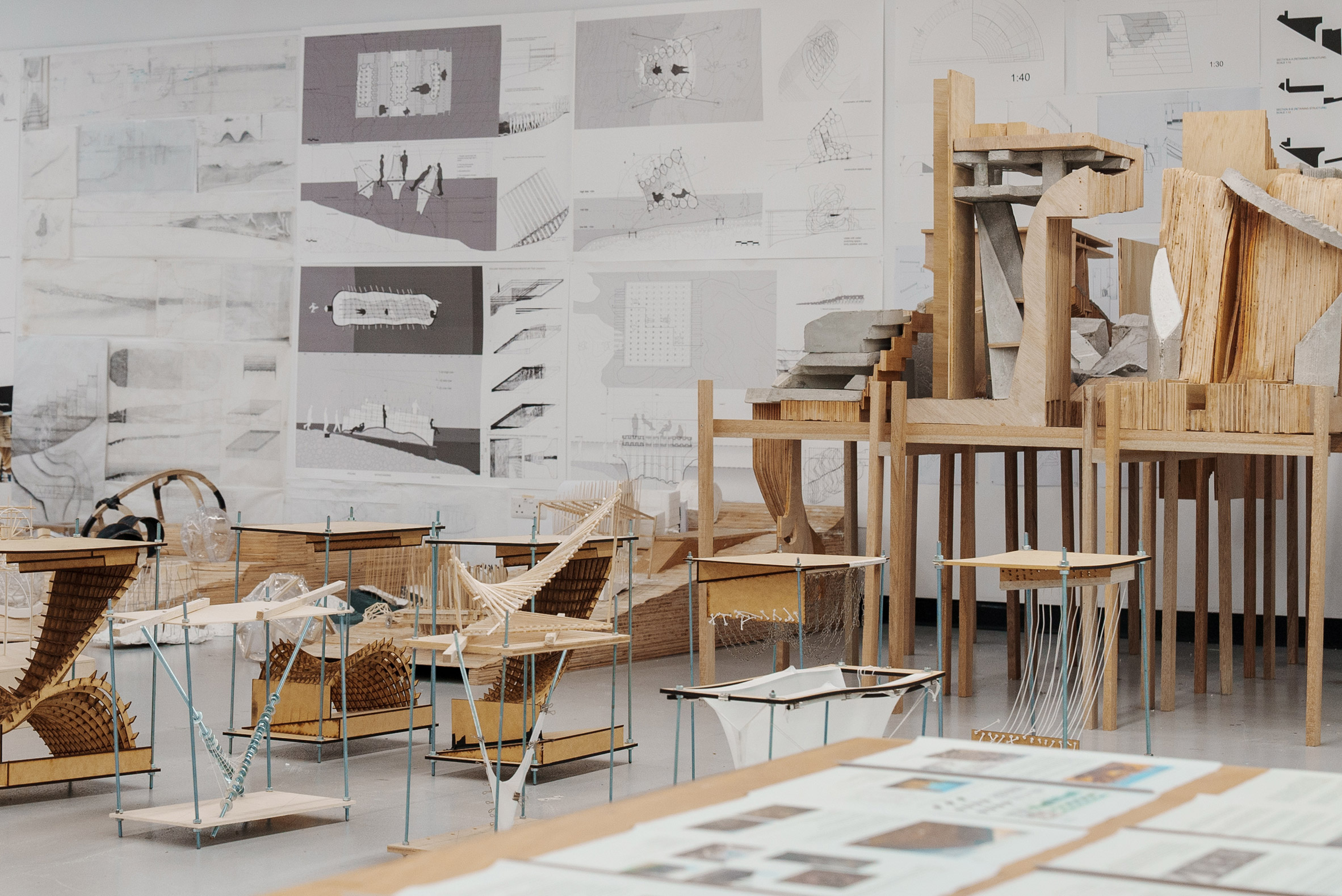 A studio space with models on floor and drawings on walls