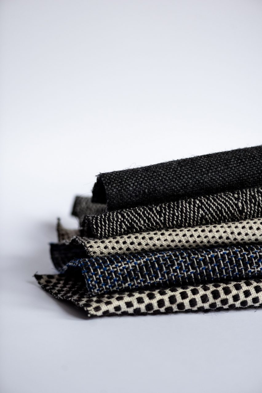 Photo of five fabrics made of human hair folded and stacked on top of each other. They each feature small geometric patterns in shades of black, white and dark blue