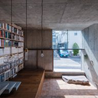 Concrete home interior with a bookshelf wall