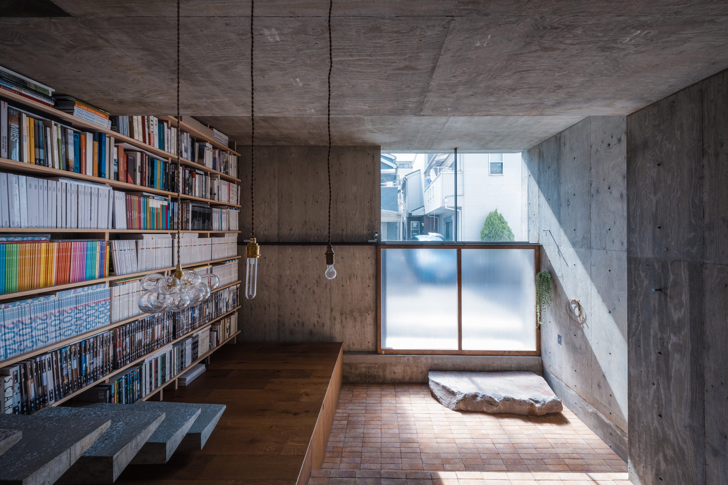 Concrete home interior with a bookshelf wall