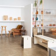 A showroom with white shelves populated with design objects