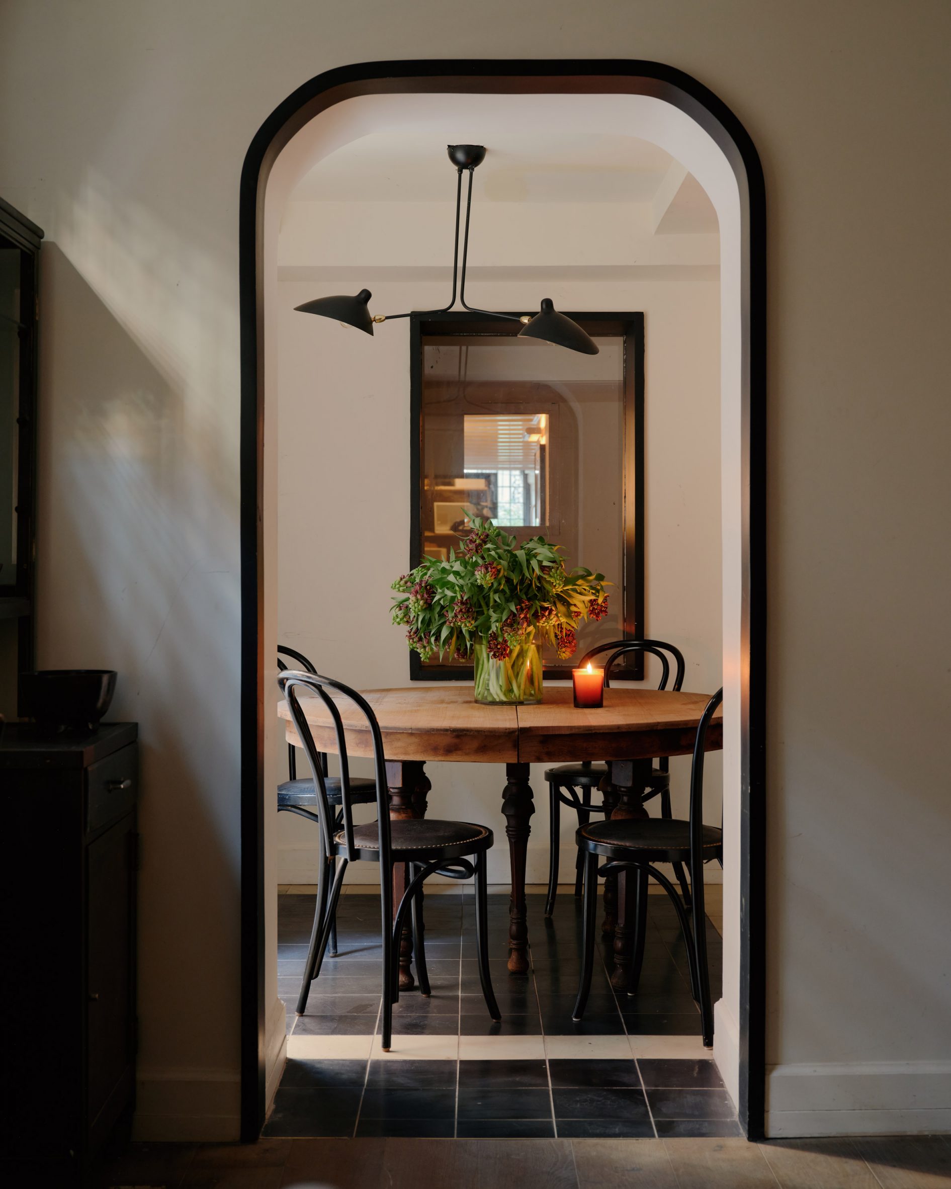 A dining table within a niche, viewed through a mahogany trimmed arch