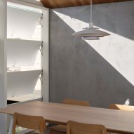 Dining room with concrete walls and a timber table