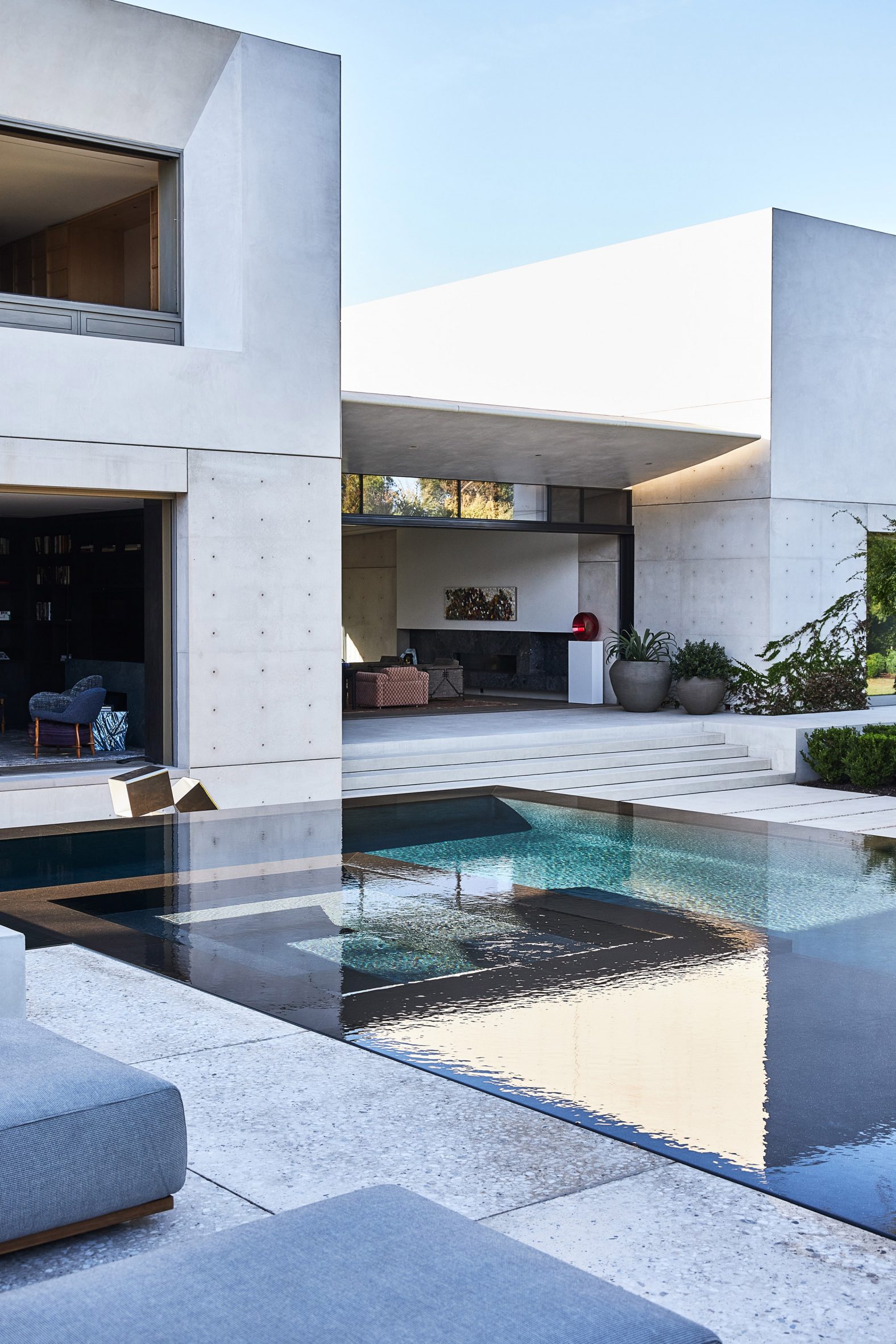 White concrete house with varied volumes and swimming pool