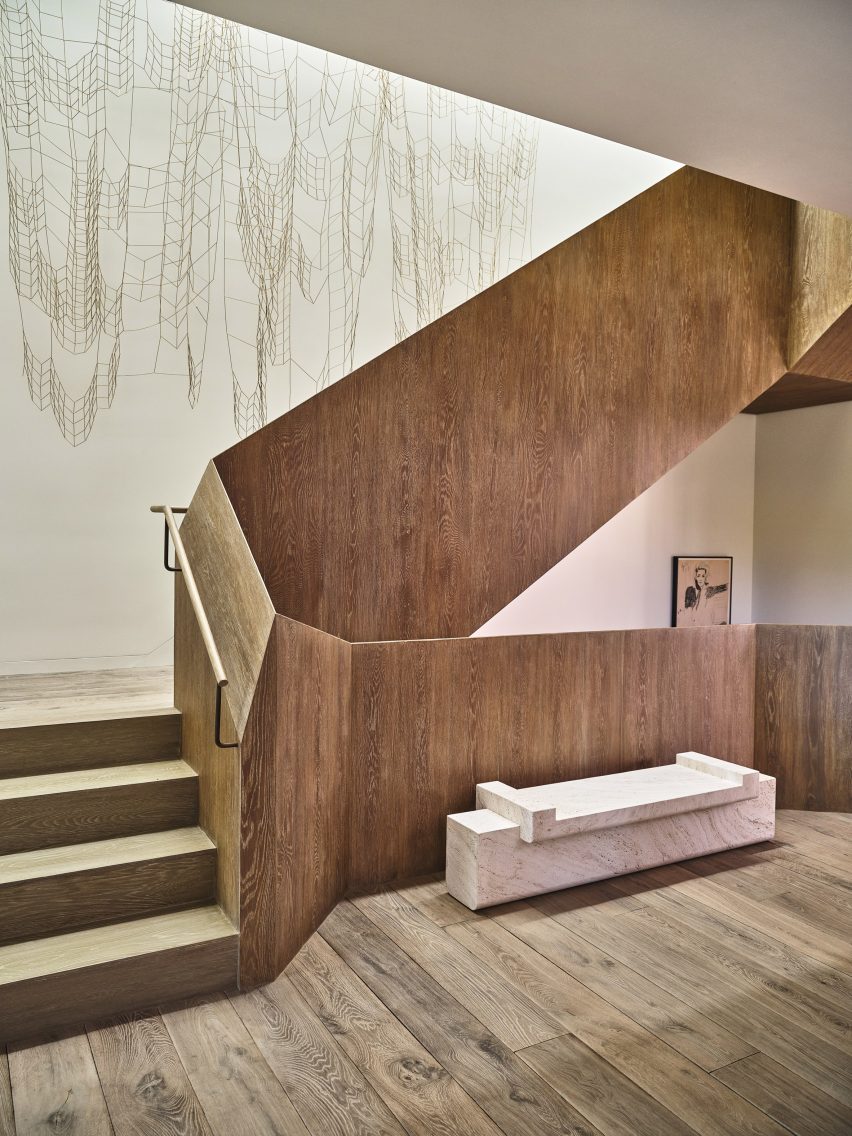 Winding wooden staircase with artworks