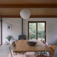 Dining room with white brick walls and timber ceilings