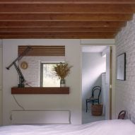 Bedroom with white brick walls and wooden beams