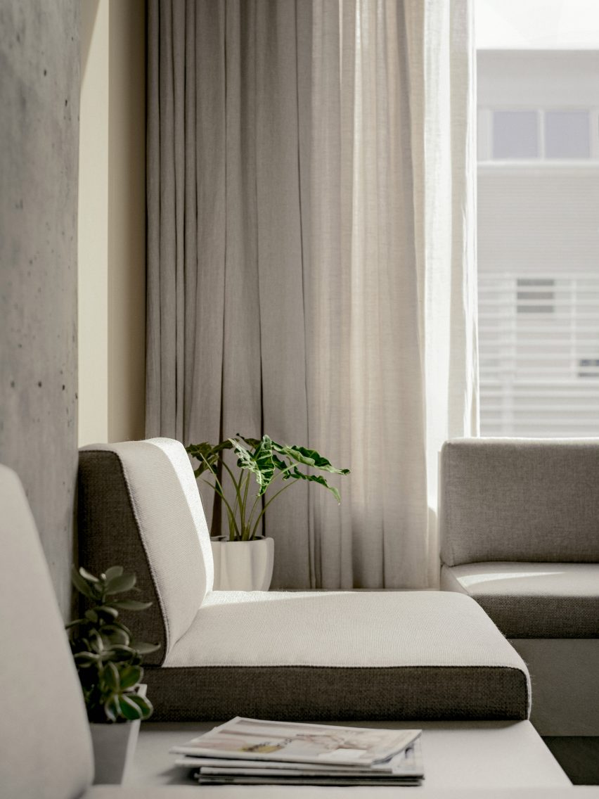Cushioned seat in front of a linen curtain