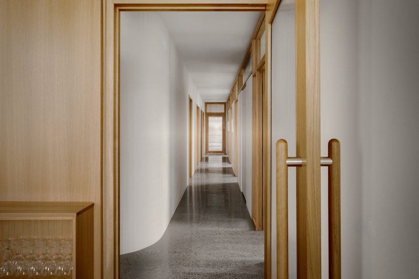 Corridor with white walls and wood-framed doors on either side