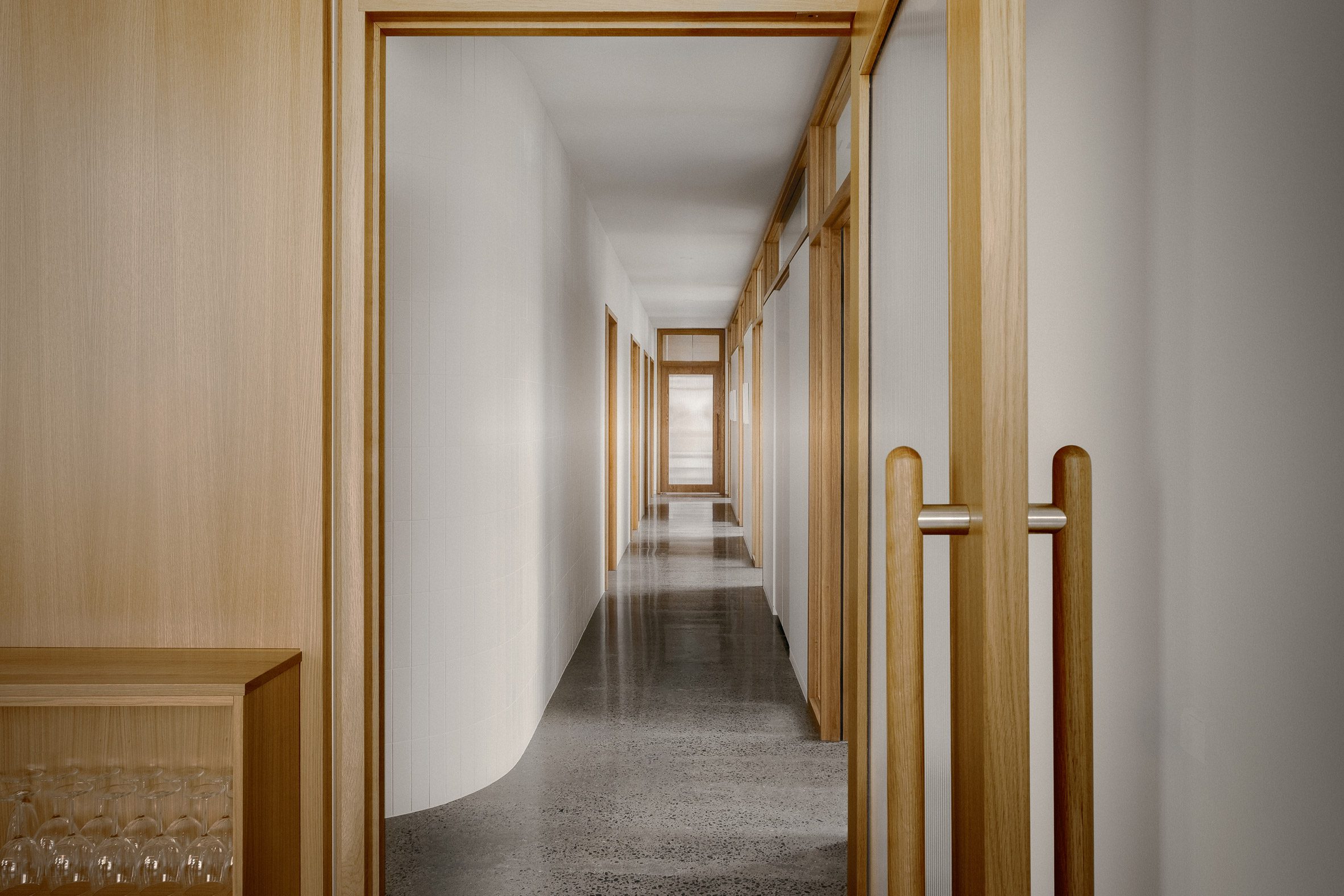 Corridor with white walls and wood-framed doors on either side