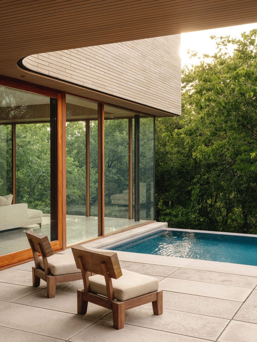Covered patio overlooking a rectilinear swimming pool